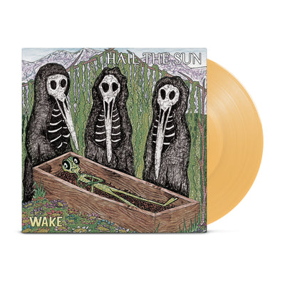 Album art of three skeletal figures standing around a casket containing a smirking green alien. Custard colored vinyl record poking out of the sleeve.