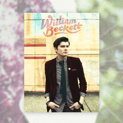 Poster against pink and green background. Poster is a picture of William Beckett in a suit jacket and tie standing with hands in pockets. The background of the poster is yellow and the top of the poster has "WILLIAM BECKETT" printed in the center.