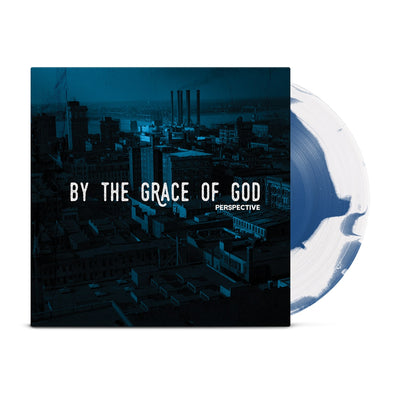 Vinyl jacket with large white text that says BY THE GRACE OF GOD across the center with smaller text below that says PERSPECTIVE. Album artwork is an image of buildings with a dark blue filter over it. peeking out of the jacket is a white and blue colored vinyl.