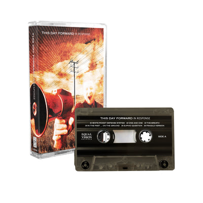 This Day Forward - 'In Response' cassette tape. The picture depicts the cassette against a white background. On the album cover is a man in a field, holding a megaphone. Above him is an orange, black, and white sky. The tape beside the album cover is a dark, transparent gray.