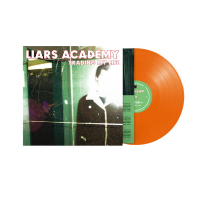 The cover of this record is a blurry photograph of a man in a dimly lit room.  Only the upper half of the mans body is showing, and his face is blocked out by the lens flare of the camera.  The vinyl itself is bright orange with a green center.