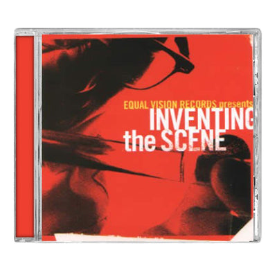 CD against white background. CD cover has a zoomed in picture of an individual with glasses holding a tube and examining it. The background of the picture is red and the individual is in black and white. The right side has "EQUAL VISION PRESENTS" printed in yellow and "INVENTING THE SCENE" printed in white.