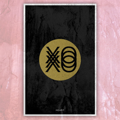 Lithograph against pink background. Lithograph is a picture of a gold circle with "XO" printed in black. There are 3 of each letter printed and they are layered on top of each other. The background is black and the bottom has "HEART" printed in the center in a small font.