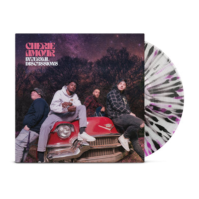 Vinyl jacket with an image of band members sitting on top of a red car. In the background are trees and the night sky, which is tinted pink along with the rest of the cover. In the top left corner there is pink text that says CHERIE AMOUR. Below that is white text that says INTERNAL DISCUSSIONS. Peeking out of the jacket is a clear vinyl with purple and black splatter.