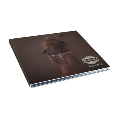 A CD case with a naked woman standing in the middle of the image. She is in room with a brown wall. She has a bird cage on her head. There are birds swirling around her. The words "Migrant" "The Dear Hunter" are in the bottom right corner.