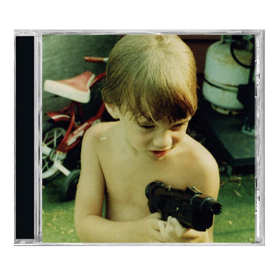 CD against white background. CD case has a picture of a shirtless child holding a gun. There is a green hue to the picture and there is a red bike in the background.